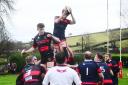 LEAP: Wiveliscombe's Jake Hopkins (blue/red kit) beats Will Hodgson of Wellington (black/red kit) to the ball at the lineout. Pics: Steve Richardson