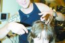 Nine year old Elliott Dommett gets ready for his head shave by senior stylist Casey Warren at Hair Associates