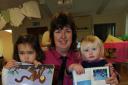 PRE-school assistant Julie Edwards, upside-down book reading with children.