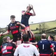 LEAP: Wiveliscombe's Jake Hopkins (blue/red kit) beats Will Hodgson of Wellington (black/red kit) to the ball at the lineout. Pics: Steve Richardson