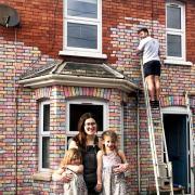 BRIGHT IDEA: Fern Taylor, 26, with her daughters Arabella, 4, and Matilda, 2, and her partner, Marco DeFazio at their chalk covered house. PICTURES: SWNS