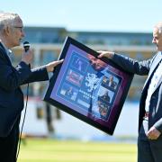 Gordon Hollins being presented a gift by Sir Michael Barber