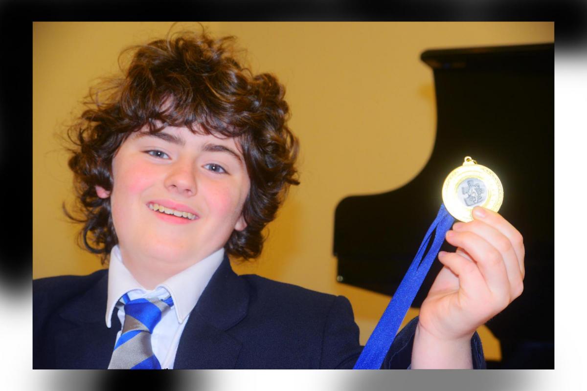 Ben Shattock with a medal he won for his jazz piano playing