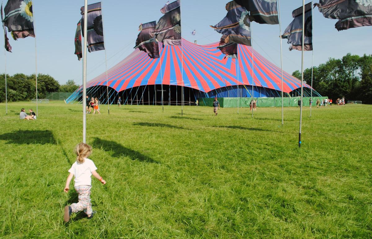 A child runs in front of the John Peel Stage at the Glastonbury Festival. June 2019. Picture: Paul Jones