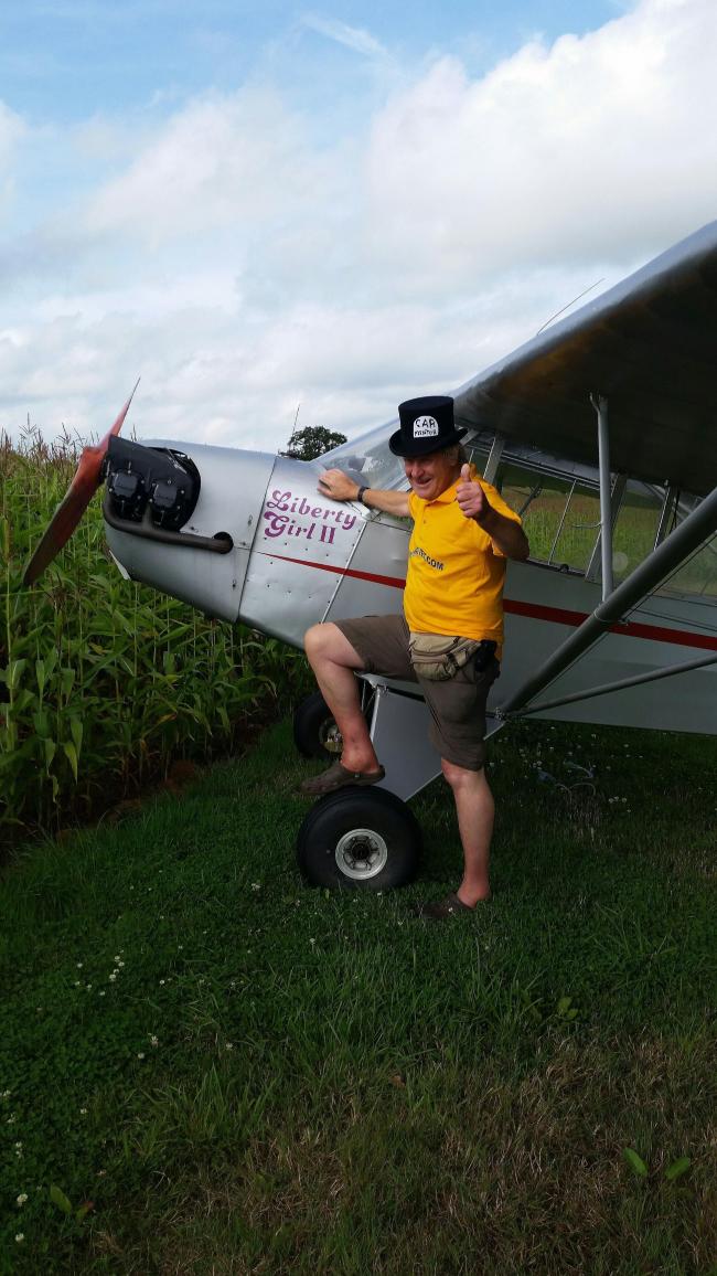 Adventurer Maurice Kirk with his plane parked up in a field near Taunton