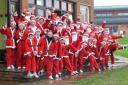 Around 50 people dressed as Father Christmas for a Santa Run in Minehead, despite the wet weather.