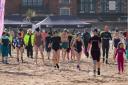 Fundraisers walk towards the sea at Minehead Beach at this year's charity dip.