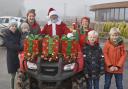 Santa is greeted by two elves and four children after arriving at Rumwell Farm Shop on a quad bike.