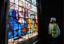 Director of Holy Well Glass, Jack Clare, inspects a newly conserved 18th-century painted glass window which has been re-installed in the Gothic 'tomb' at the National Trust's The Vyne near Basingstoke