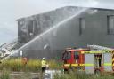 Fire crews using hoses to extinguish the blaze.