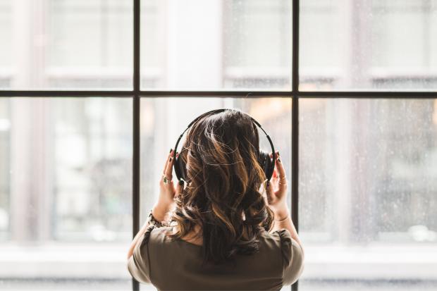 Somerset County Gazette: A woman listening to music on her headphones. Credit: Canva