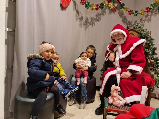 FESTIVE: Santa discusses Christmas gifts with some local children