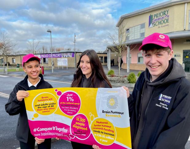 Somerset County Gazette: CHARITY: Students at Priory Community School proudly display a Brain Tumour Research banner and wear pink charity-branded hats
