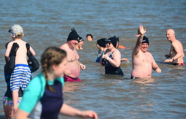 Somerset County Gazette: A charity swimmer waves at our photographer while swimming in the sea.