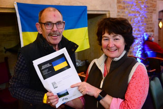 Somerset County Gazette: Tim Prior and Sue Watson in front of a Ukrainian flag at the fundraiser.