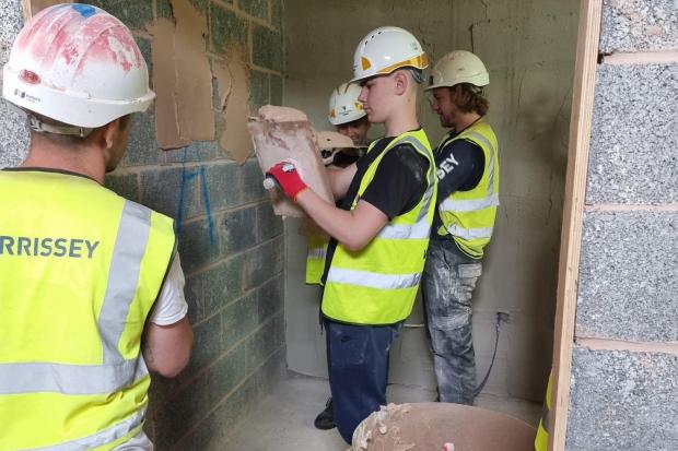Sky Academy students try their hand at plastering the walls