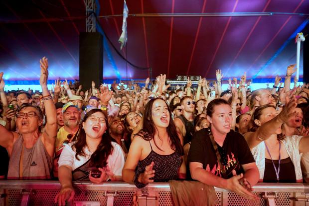 Somerset County Gazette: The crowd watches Glastonbury founder Michael Eavis performing with his band in the William's Green tent. Picture: Yui Mok, PA Wire