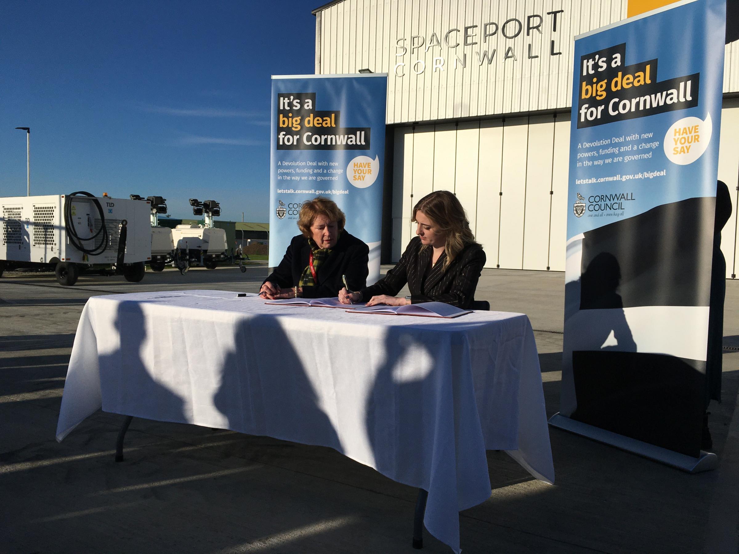 Cornwall Council leader Linda Taylor and Levelling Up minister Dehanna Davison sign the Cornwall Devolution deal at Spaceport Cornwall (Image: Richard Whitehouse/LDRS)