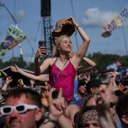 A woman watches soul singer Diana Ross on the Pyramid Stage at Glastonbury Festival 2022.