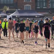 Fundraisers walk towards the sea at Minehead Beach at this year's charity dip.