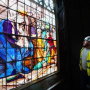 Director of Holy Well Glass, Jack Clare, inspects a newly conserved 18th-century painted glass window which has been re-installed in the Gothic 'tomb' at the National Trust's The Vyne near Basingstoke