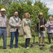 A pear tree was planted in The Grange’s orchard by shoemaker Howard Burch and Angela Southern (right of the tree).