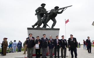 D-Day veterans pose for pictures at the British Normandy memorial statue.